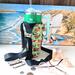 The side of a green sushi print water bottle bag is displayed with money, eye glasses and chap stick while the bag is holds a 40 oz Stanley.